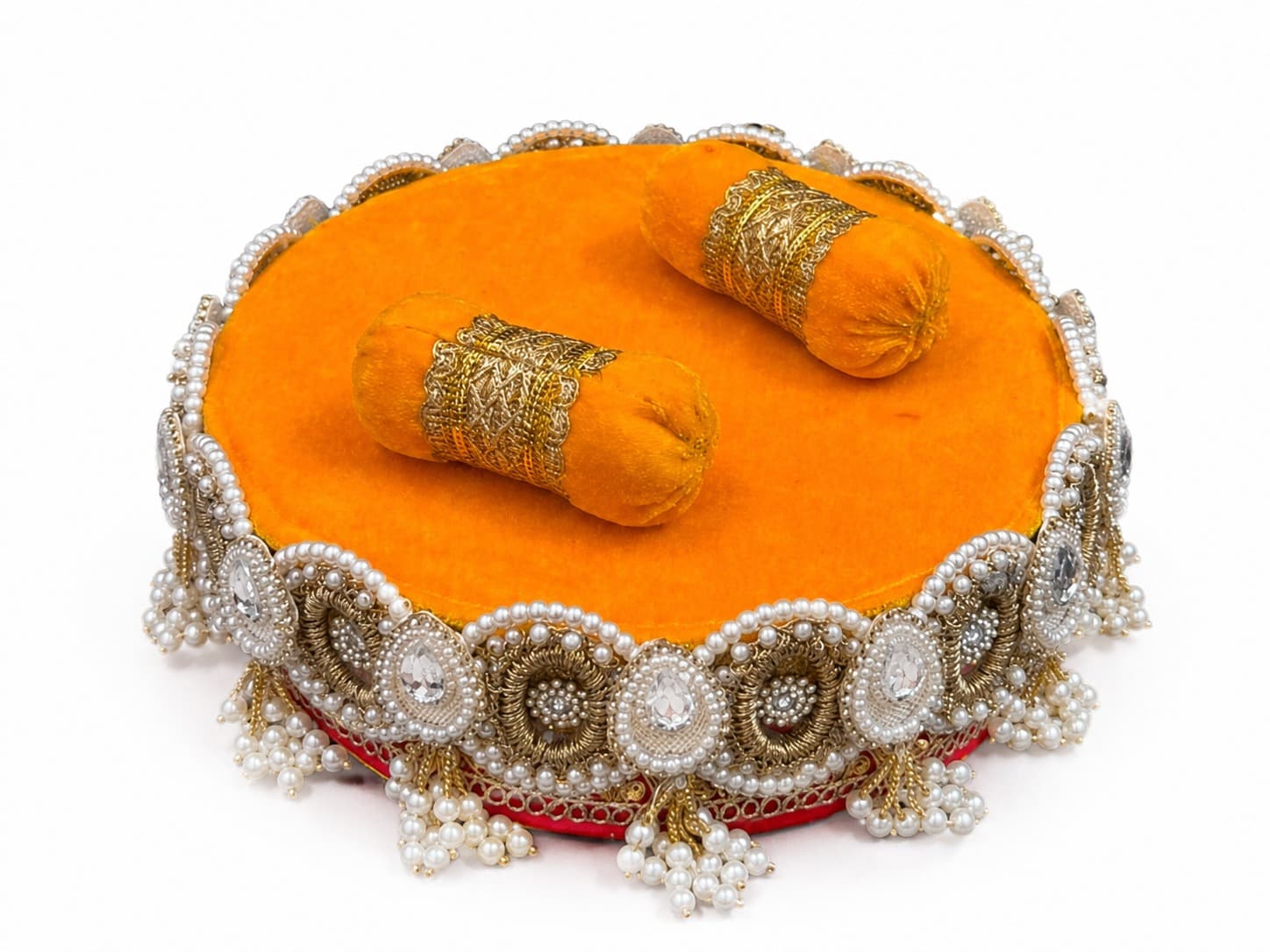 Marigold velvet round gadi with gold-banded bolsters and a pearl and kundan border